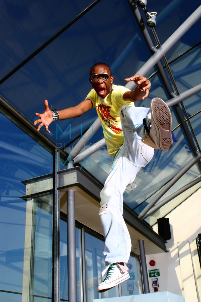 UK Garage artist Daniel 2 Dark captured mid-air in a dynamic action jump beneath the glass roof canopy at Metro Daylight Studios in London, photography by Music Man Studio.