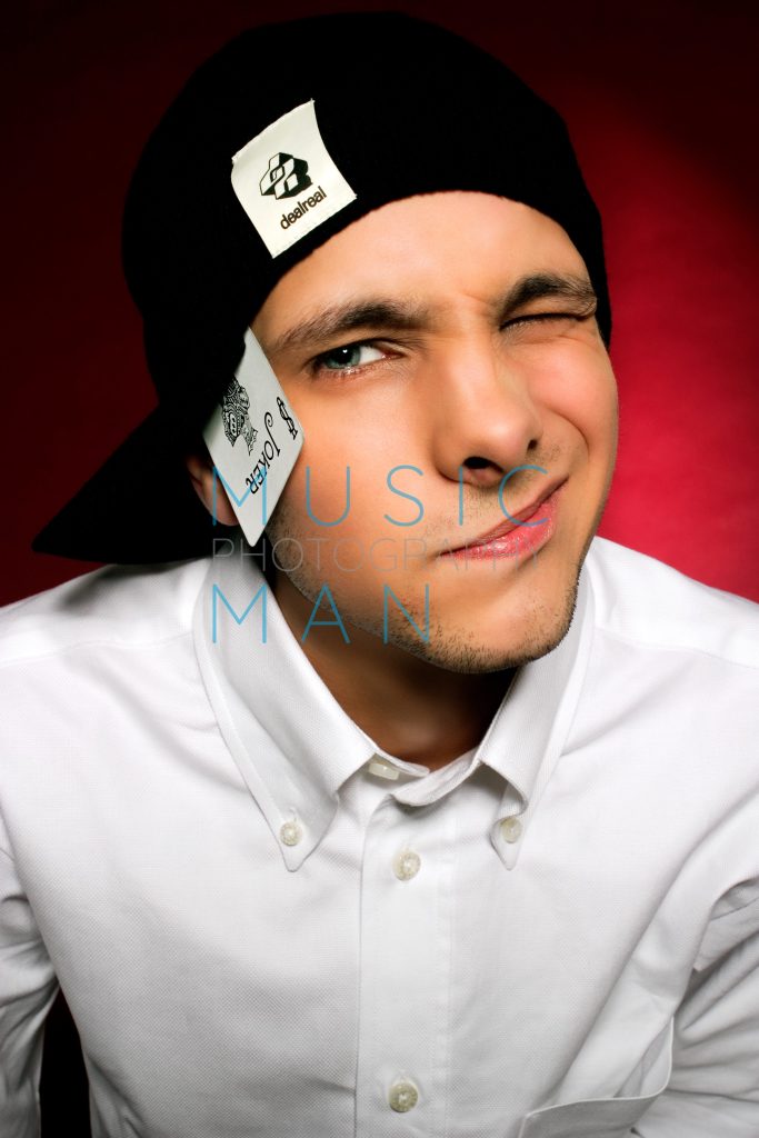 Magician Dynamo posing with a Joker playing card tucked in his cap during an exclusive Clerkenwell studio portrait session for the Body and Soul charity campaign, photography by Music Man Studio.