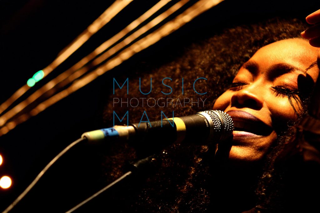 Singer Erykah Badu captured in a powerful vocal close-up performance on stage at the Brixton Academy in London, photography by Music Man Studio.