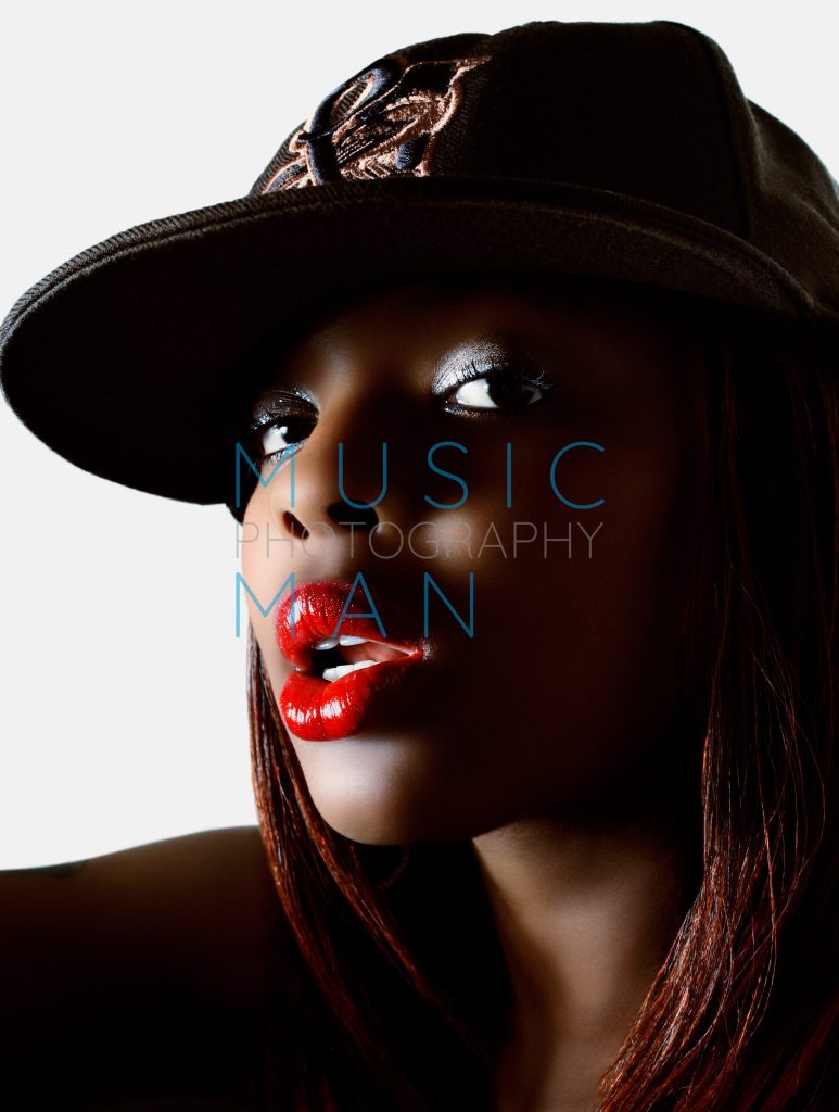 R&B and soul singer Nicole Wray, also known as Lady Wray, posing in a black embroidered baseball cap and glossy red lipstick during an exclusive studio portrait session, photography by Music Man Studio.