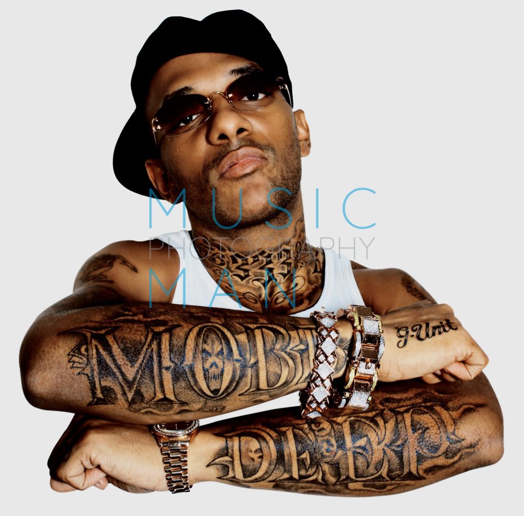 Mobb Deep rap artist Prodigy posing with crossed arms displaying his MOBB DEEP and G-Unit forearm tattoos during an exclusive studio portrait session in London, photography by Music Man Studio.