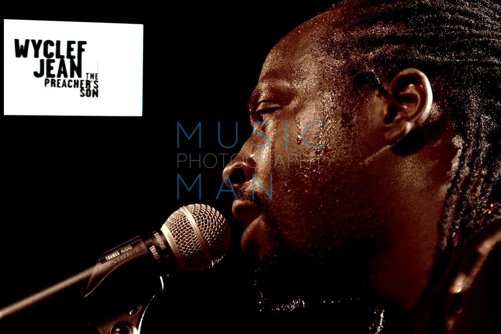 Fugees member Wyclef Jean captured in a high-contrast close-up profile performance during his exclusive Preacher's Son album press showcase in London, photography by Music Man Studio.